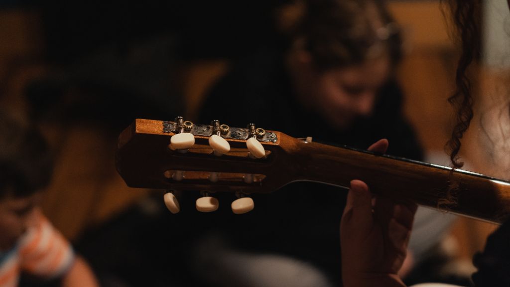 Close-up of an acoustic guitar headstock during a lesson at the Kaleo studio