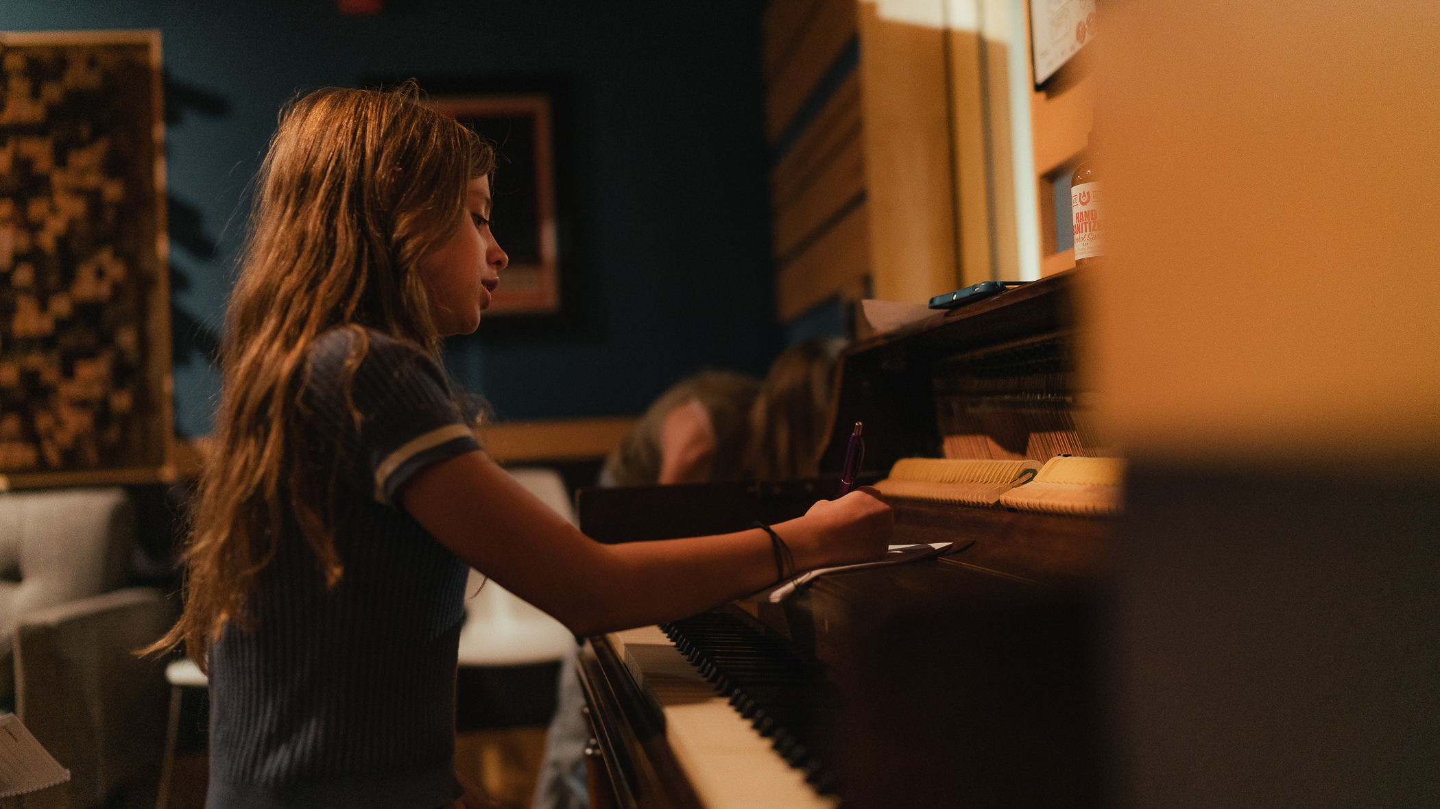 A young songwriter sits at the piano in the Kaleo studio, mid-thought, working out a melody